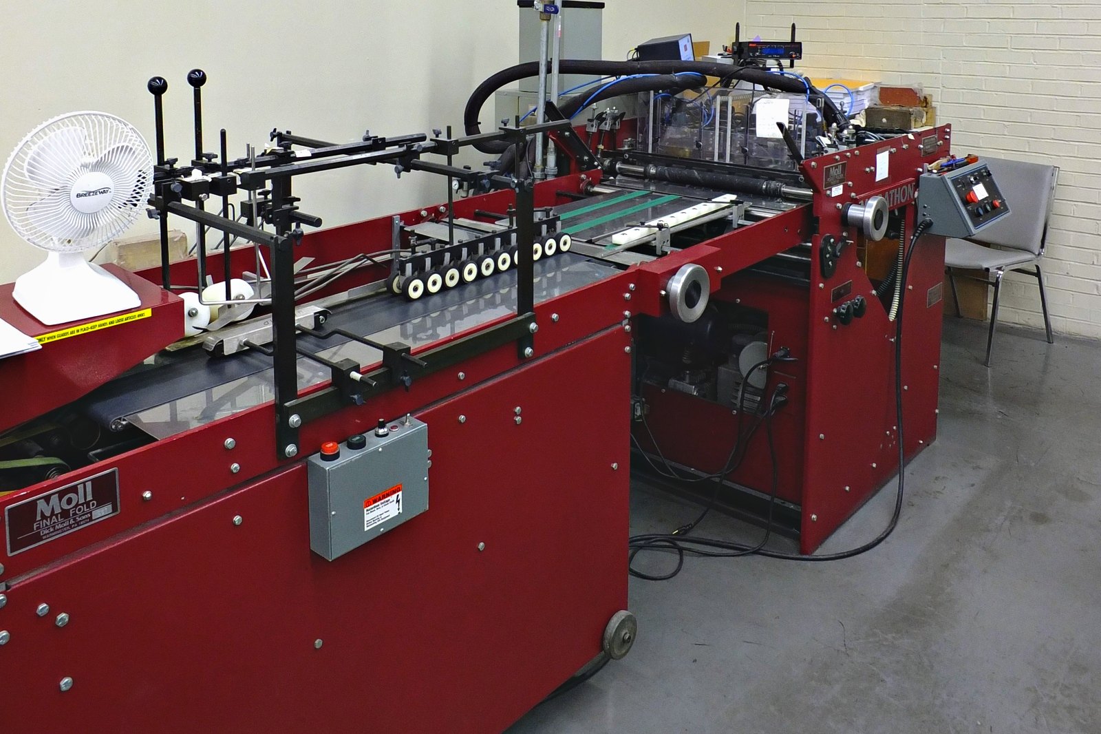 The Moll folder gluer that forms and glues pocket folders at Broudy Printing