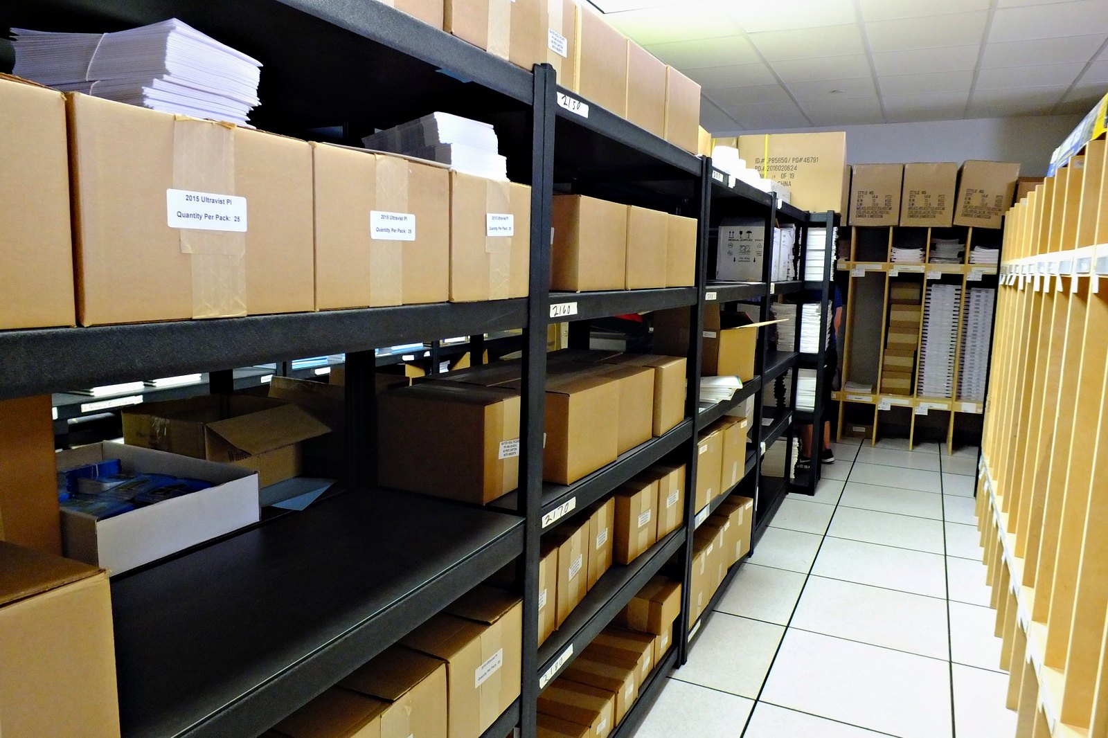 Labelled cartons of customer inventory on shelving at Broudy Printing