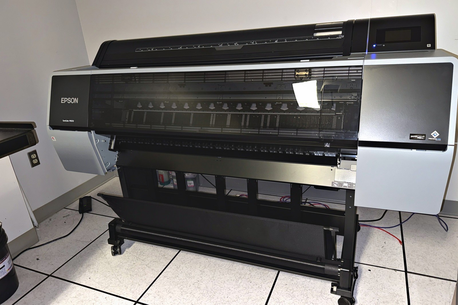 A wide-format inkjet printer at Broudy Printing, loaded with roll media